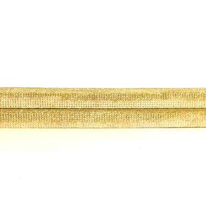 May include: Two stacked gold-colored rectangular platforms made of a textured material. The platforms are ideal for displaying small items.