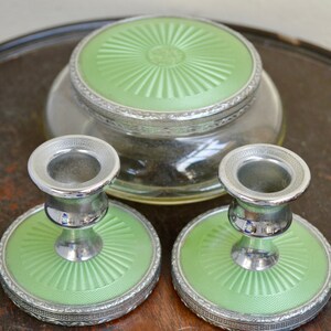 K&ouml;nnte beinhalten: Ein Set aus drei Vintage-Schminkutensilien in Gr&uuml;n und Silber. Das Set enth&auml;lt ein rundes Glas mit Deckel und zwei Kerzenhalter mit passenden Sockeln.