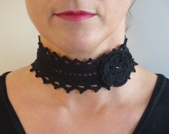 May include: A black crocheted choker necklace with a large black crocheted flower accent.