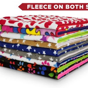 May include: A stack of 10 colourful fleece blankets with various patterns, including hearts, stars, and paw prints. The text "Fleece on Both Sides" is displayed above the stack.