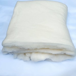 Può includere: Un'imbottitura di cotone bianco piegata, un materiale morbido e soffice utilizzato per la trapunta, l'artigianato e la tappezzeria.