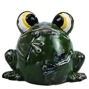 May include: A small, glossy, dark green ceramic frog figurine with large, prominent eyes featuring yellow irises and black pupils. The frog is depicted in a seated position with its front legs resting against its rounded body, showcasing a smooth, reflective surface finish.