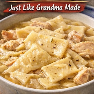 Puede incluir: Un plato de pollo con albóndigas. El plato presenta albóndigas grandes y cuadradas en un caldo cremoso con trozos de pollo. El texto "Just Like Grandma Made" se muestra en la parte superior de la imagen.