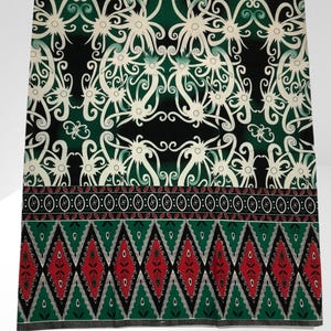 May include: Green and black fabric with a white floral pattern and a red and green diamond pattern at the bottom.