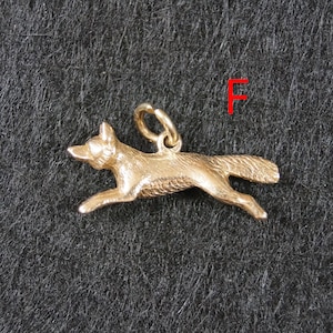 May include: A gold-toned metal charm shaped like a running fox with textured fur details and a small circular jump ring attached to the top. The letter F is printed in red in the upper right corner of the frame, positioned above the fox charm.