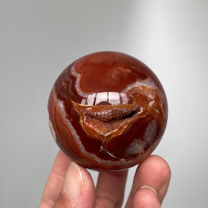 Op de afbeelding: Een set van drie keramische mokken met een gespikkelde, matte afwerking. De mokken zijn in tinten crème, lichtgrijs en donkergrijs. Elke mok heeft een eenvoudig, minimalistisch ontwerp, perfect voor koffie of thee.