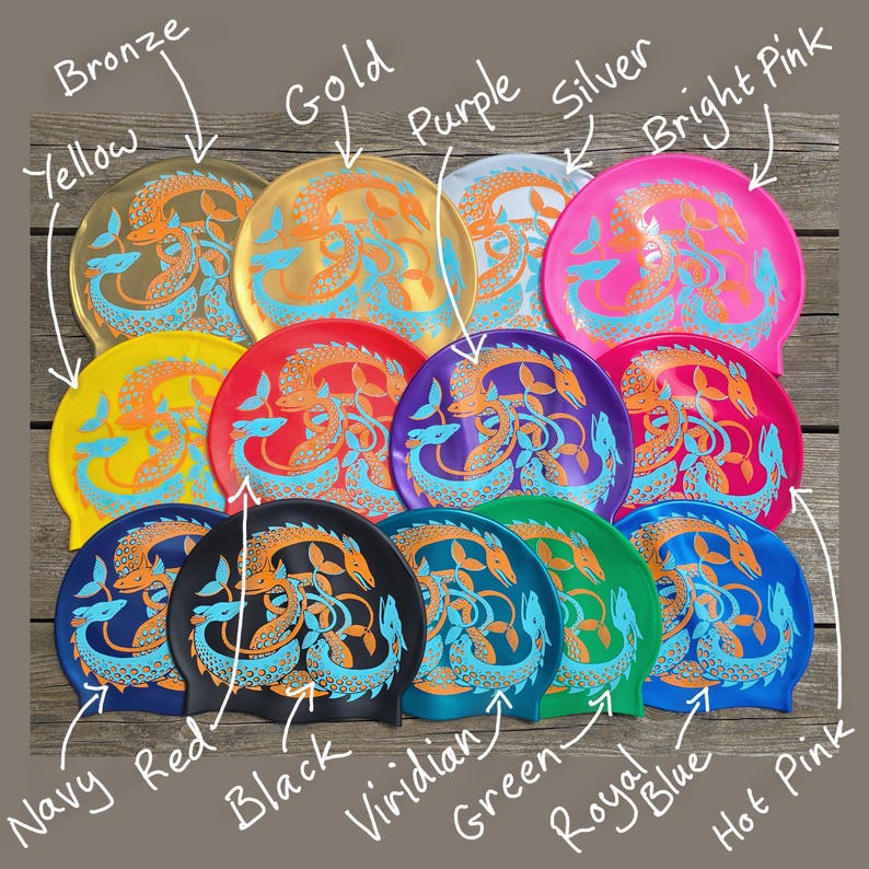 May include: A collection of colorful swim caps in various shades, including yellow, gold, red, purple, and bright pink. Each cap features a teal and orange dragon design. The caps are labeled with their respective colors.