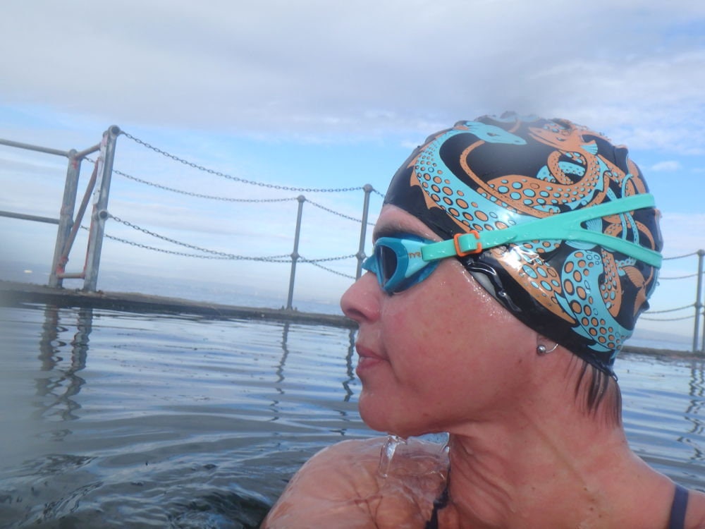 Sea Dragons - Nancy Farmer swimming hat / swim cap. Orange & Turquoise print on a choice of backgrounds. Open water swimming.