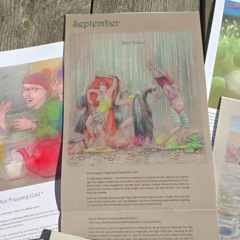 Op de afbeelding: Een kalenderpagina getiteld September met een illustratie genaamd Rain Dance. Het kunstwerk toont drie figuren die in de regen dansen en kleurrijke kleding dragen. Onder de illustratie staat gedrukte tekst die de maand en het kunstwerk beschrijft.