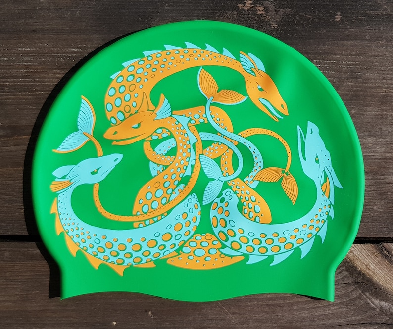 May include: A bright green swim cap featuring a repeating design of stylized sea serpents in orange and light blue. The serpents are intertwined, creating a dynamic and eye-catching pattern. The cap is made of a flexible material.