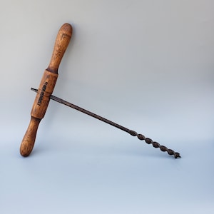May include: A vintage wooden handled drill bit with a metal twist drill bit. The handle is marked "Townsend" in black lettering.