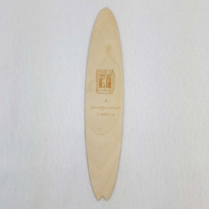 May include: A wooden surfboard bookmark with the text "A Imagination Creation" and "Made in Cornwall" printed on it.