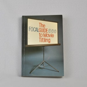 May include: A book titled "The Focalguide to Movie Titling" with a picture of a projector screen on a tripod stand.