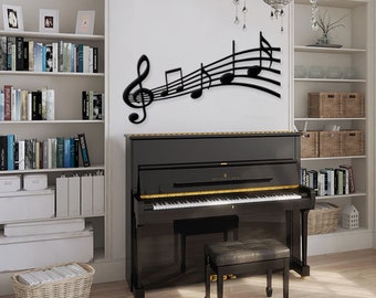 May include: A black grand piano with a matching piano bench in a room with white walls and bookshelves. A black metal wall art piece depicting musical notes and a treble clef is on the wall above the piano.