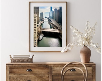 May include: A framed photograph of a cityscape with a river running through it. The river is lined with buildings and bridges. A boat is visible in the river.