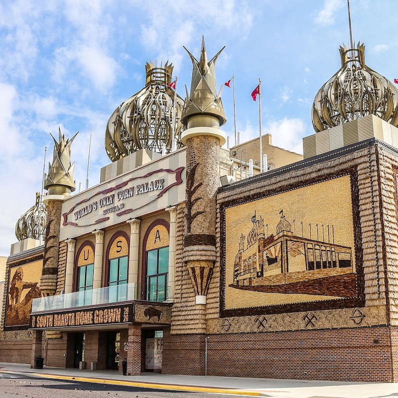 May include: The World's Only Corn Palace in Mitchell, South Dakota, is a building decorated with colorful murals made from corn, grains, and seeds. The building has a large sign that reads "World's Only Corn Palace" and a smaller sign that reads "South Dakota Home Grown".