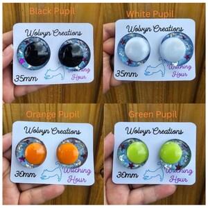 May include: Four pairs of handmade resin eye cabochons with black, white, orange, and green pupils. Each pair is on a white card with the text "Wolvyn Creations", "Witching Hour", and size measurements of 30mm or 35mm.
