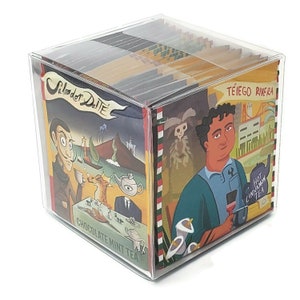 May include: A clear plastic box filled with 20 individually wrapped tea bags. The box features colorful illustrations of people and places. The tea flavors are "Chocolate Mint Tea" and "Hot Cinnamon Tea".