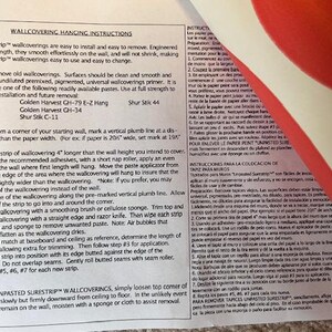 May include: Printed instructions for hanging wallpaper, with text in English and Spanish. The document details preparation, application, and removal of Surestrip wallcoverings. A red and white design is visible in the background.