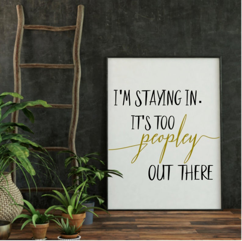 May include: A white framed print with black text that reads "I'm staying in. It's too peopley out there." The text "peopley" is written in gold.