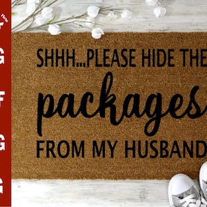 May include: A brown doormat with the text "SHHH...PLEASE HIDE THE packages FROM MY HUSBAND" in black lettering.