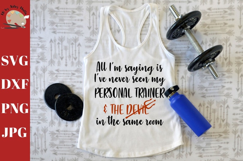 May include: White tank top with the text "All I'm saying is I've never seen my PERSONAL TRAINER & THE DEVIL in the same room". The text is in black with a red devil symbol.