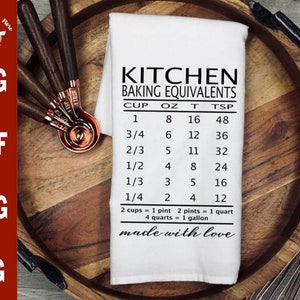Puede incluir: Una toalla de cocina blanca con texto negro que dice "Kitchen Baking Equivalents" y una tabla de medidas para tazas, onzas, cucharadas y cucharaditas. El texto en la parte inferior dice "made with love".