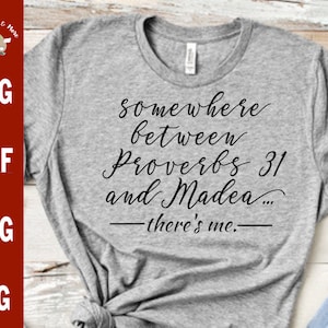 Puede incluir: Camiseta gris con texto negro que dice "somewhere between Proverbs 31 and Madea... -there's me.-"