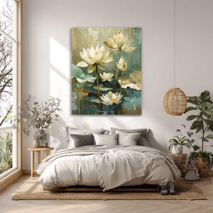 May include: An oil painting of white lotus flowers with yellow centers and green lily pads. The artwork is displayed above a bed with neutral-colored bedding. The room has a large window and a woven pendant light.