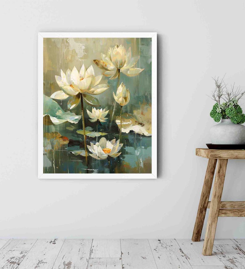 May include: A framed painting of white lotus flowers with yellow centers and green lily pads. The artwork has a soft, impressionistic style with a muted color palette of greens, blues, and creams. The painting is displayed on a white wall.