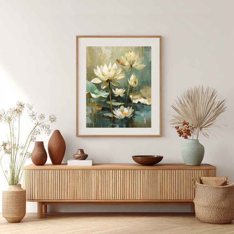 May include: A framed art print featuring a watercolor painting of white lotus flowers with yellow centers, green lily pads, and a teal and green background. The artwork is displayed above a wooden cabinet with decorative vases and a woven basket.