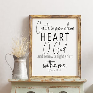 Puede incluir: Una impresión enmarcada con fondo blanco y texto negro. El texto dice "Crea en mí un corazón limpio, oh Dios, y renueva en mí un espíritu recto. SALMO 51:10". El marco es de madera marrón con un acabado desgastado.