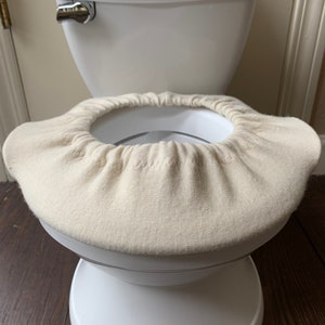 May include: White toilet seat cover with a white toilet seat underneath. The toilet seat is labeled "summer."