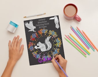 May include: A black coloring book titled "Animal Mandalas Coloring Book 80 Pages" with illustrations of an eagle, toucan, and squirrel. A hand is coloring the book with a purple pencil. Colored pencils and a mug of coffee are also on the table.