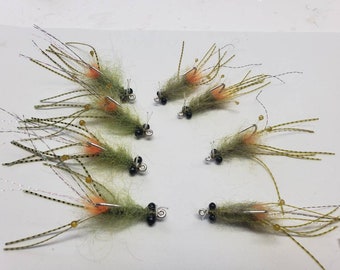 May include: Eight green and orange fly fishing lures with black beads and gold accents.