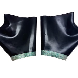 Pu&ograve; includere: Un paio di scaldamani in lattice nero con un bordo di glitter argentato.