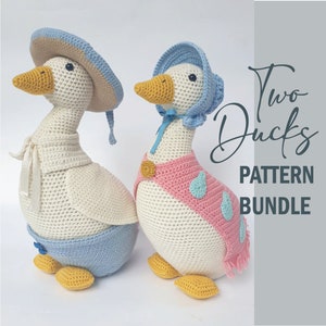 May include: Two crocheted duck amigurumi patterns. One duck is wearing a blue bonnet and a pink scarf with blue accents. The other duck is wearing a blue bonnet and a white scarf. The text "Two Ducks Pattern Bundle" is in the background.