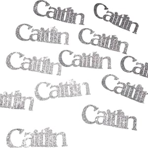 May include: Silver glitter confetti with the name "Caitlin" spelled out on each piece.