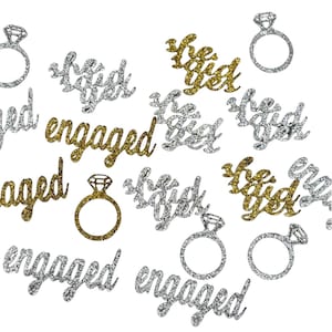 May include: Gold and silver glitter confetti with the words "engaged", "she said yes", and "be engaged" and diamond ring designs.