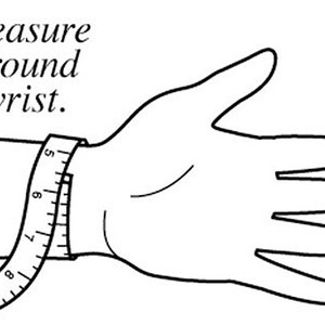 May include: Line drawing showing a hand with a measuring tape wrapped around the wrist. The text "Measure around wrist" is above the hand. The tape shows measurements in inches, indicating how to measure for a bracelet or watch.