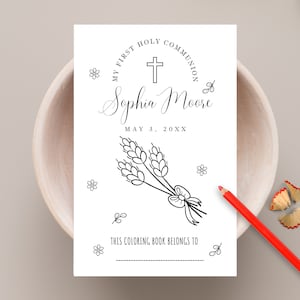 May include: A black and white colouring book with a cross, wheat stalks, and the text "My First Holy Communion Sophia Moore May 3, 20XX This Colouring Book Belongs To".