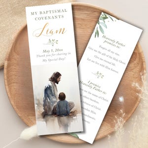 May include: Baptismal covenant cards with watercolor illustrations. One card features the name "Liam" in elegant script, date, and a thank you message. The other card has text about Heavenly Father's promises and the promise to Heavenly Father.