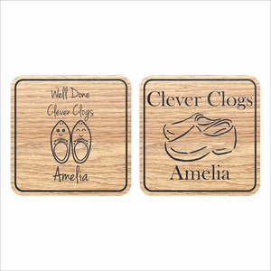 May include: Two wooden plaques with the text "Clever Clogs" and "Well Done Clever Clogs" with a drawing of a pair of clogs. The name Amelia is written below the text on both plaques.