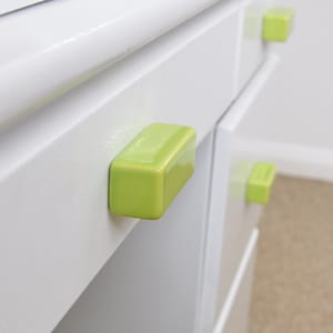 May include: White cabinet with bright green rectangular drawer pulls. The cabinet has multiple drawers and a clean, modern design. The green pulls provide a pop of colour against the white.