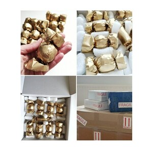 May include: A box filled with individually wrapped gold-coloured chocolates, ready for shipping. The box is labelled "Fragile" and has arrows indicating the correct way to handle the package.