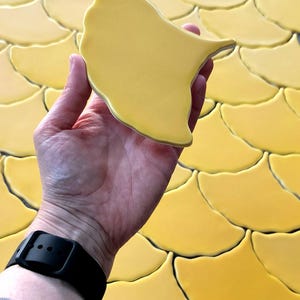Azulejo de cerámica artesanal con forma de hoja de ginkgo: mosaico amarillo mostaza mate.