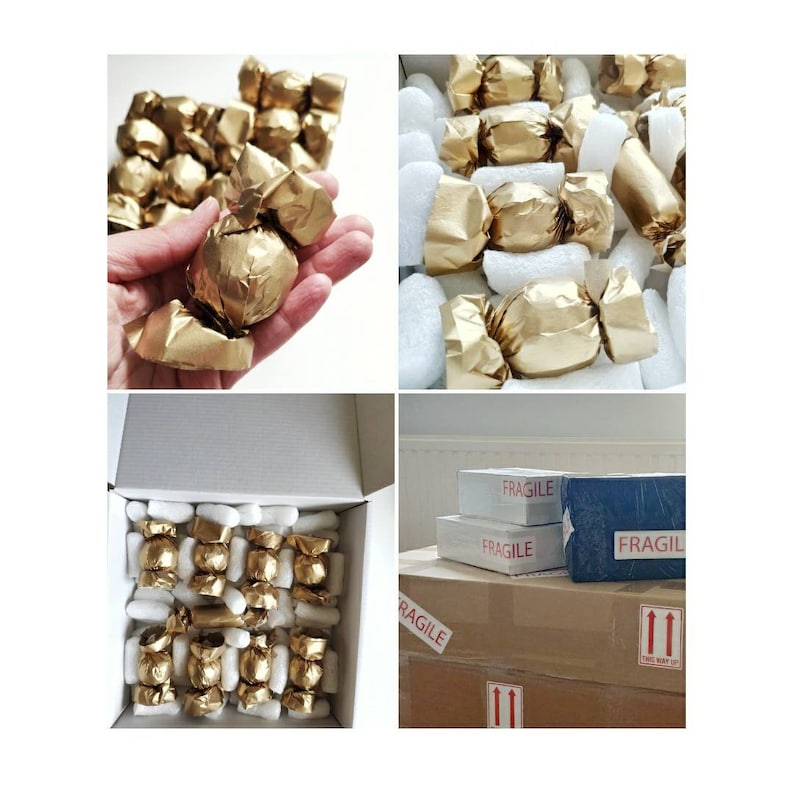 K&ouml;nnte beinhalten: Eine Schachtel gef&uuml;llt mit einzeln verpackten goldfarbenen Pralinen, bereit zum Versand. Die Schachtel ist mit "Fragile" beschriftet und hat Pfeile, die die richtige Handhabung des Pakets anzeigen.