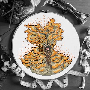 May include: A cross-stitch embroidery in a white hoop features a detailed design of a fungus in shades of orange, brown, and gray. The artwork is surrounded by embroidery floss, a measuring tape, and a small skeleton, suggesting a craft or hobby theme.