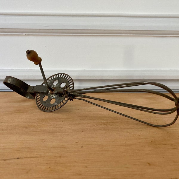 Old manual egg beater with wooden handle