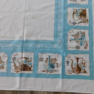 May include: White tablecloth with a light blue border and decorative square panels. The panels feature illustrations of teapots, watering cans, and vases with floral arrangements. The border has a heart and scroll design.